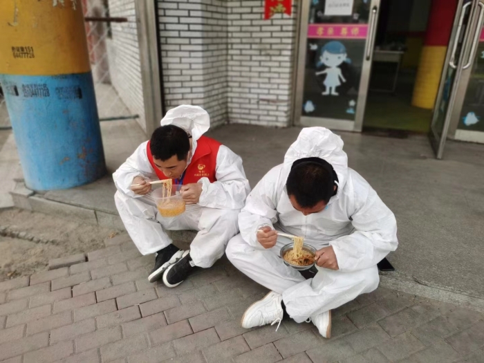 苍晓生（右一）与志愿者在值守卡点吃简易午餐